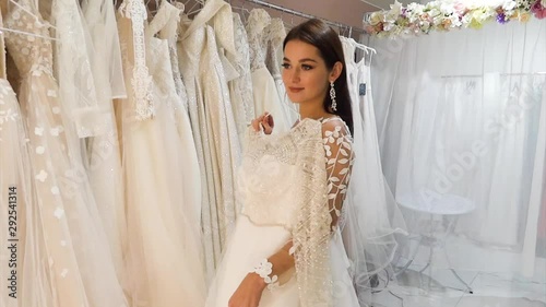 Young bride chooses dresses in a wedding salon.