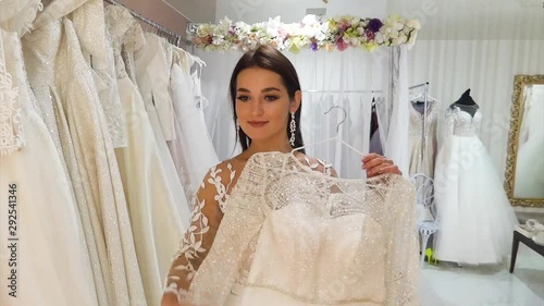 Young beautiful bride chooses dresses in a wedding salon.