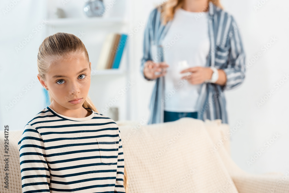 selective focus of sick kid near mother in living room selective focus of sick kid near mother in living room