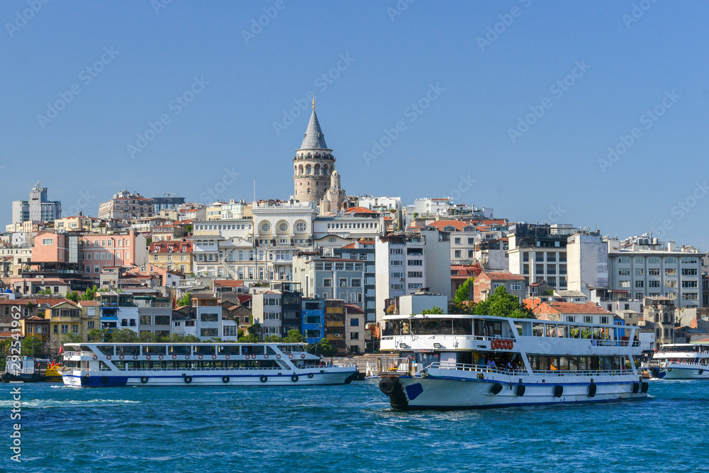 Istanbul cityscape including historical Galata Tower, Boshphorus,  passenger boats, and bridge