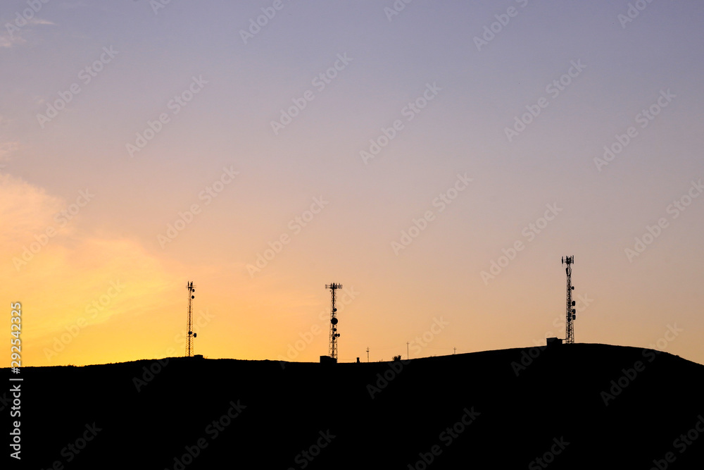 Mountain silhouette with communication towers on sunset.  Cell towers.