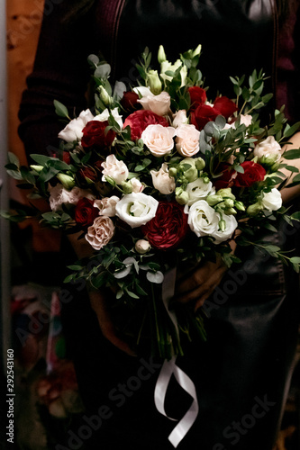Woman florist with wedding bouquet of roses.