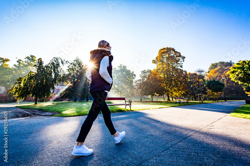 Middle-aged woman walking in city park photo