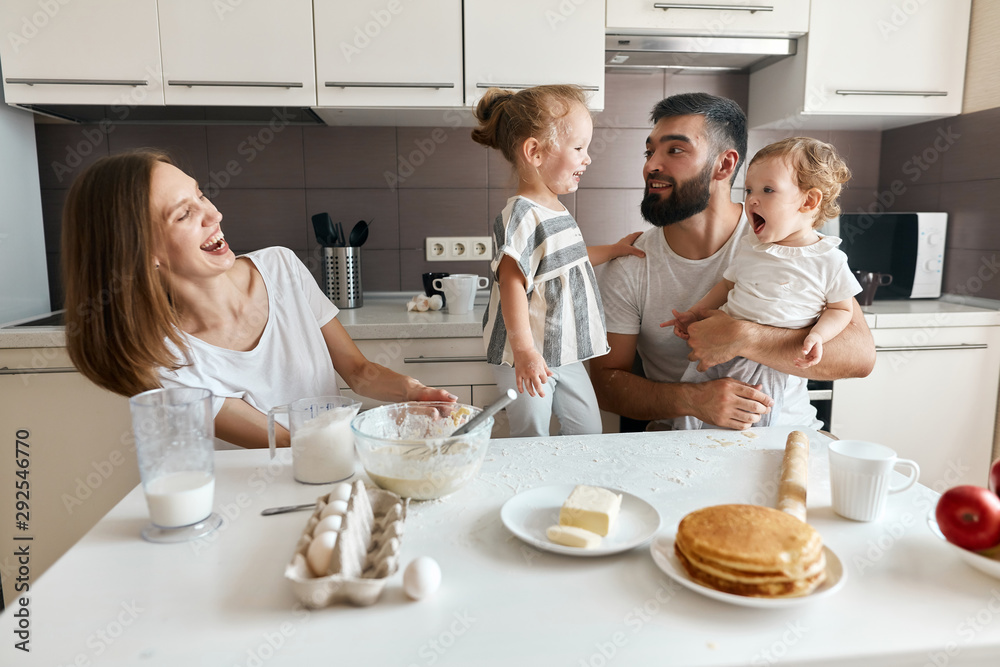 attractive mother laughing at her husband and kids. close up photo. attractive mother laughing at her husband and kids. close up photo.