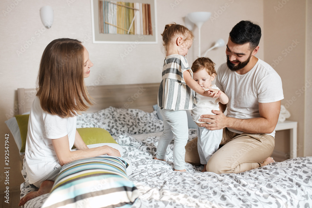 young parents teaching their elder daughter to take care, look after her little sister, close up photo. happy parenthood, fatherhood, motherhood young parents teaching their elder daughter to take care, look after her little sister, close up photo. happy parenthood, fatherhood, motherhood