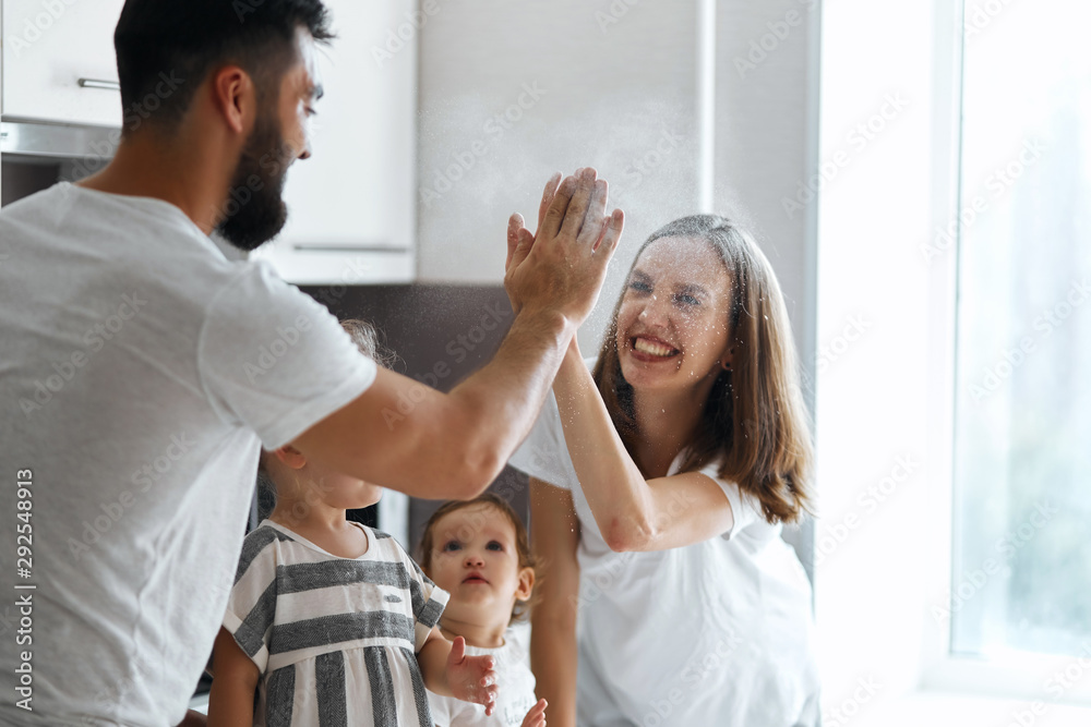 cheerful father and mother performing high five gesture, being happy to cook together, close up photo cheerful father and mother performing high five gesture, being happy to cook together, close up photo