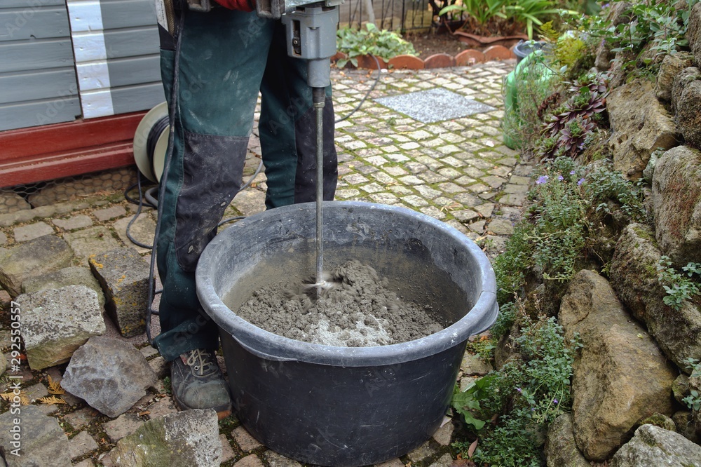 Worker pouring cement mix concrete in bucket Stock Photo