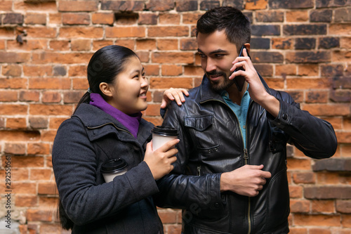 young man is simultaneously talking with the girl and on the phone photo