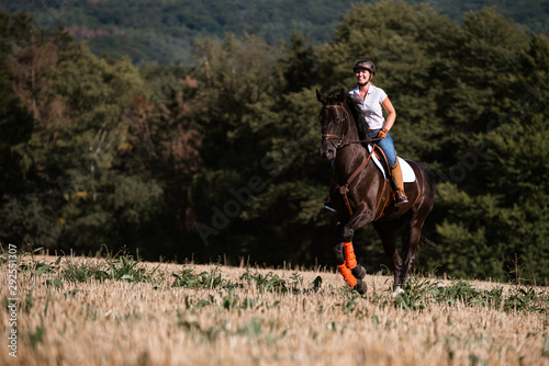 Reiterin galoppiert auf dem Feld mit ihrem Pferd