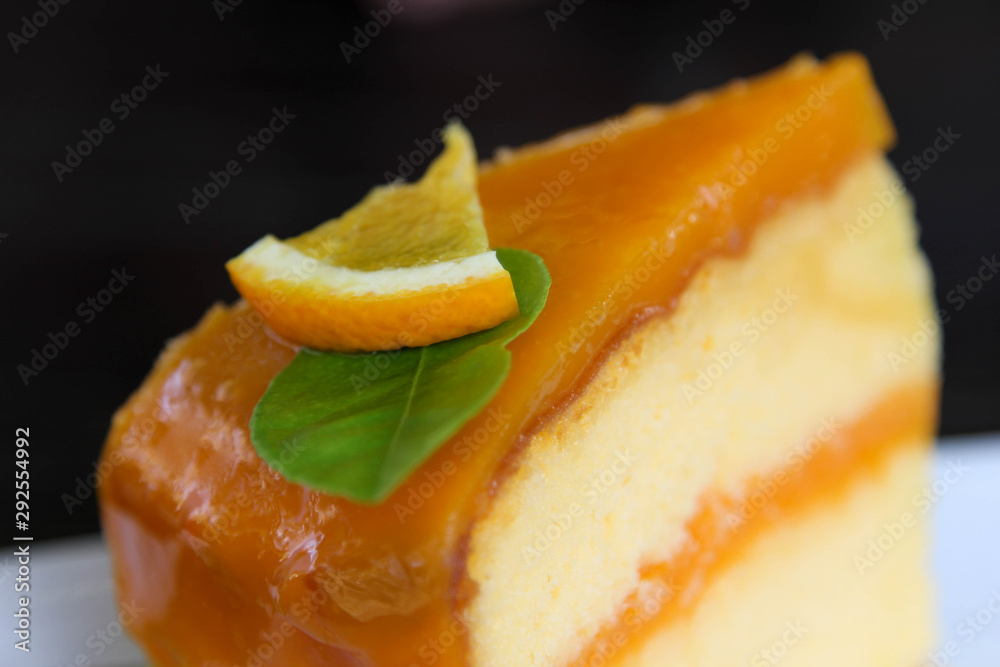 Orange cake in white dish on black background. Orange cake in white dish on black background.
