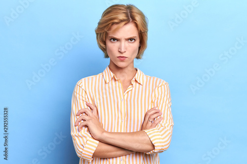 Angry unhappy sad woman looking at camera with sceptical and displeased expression, arms crossed. Portrait of beautiful female boss disappointed or angry with her office workers photo