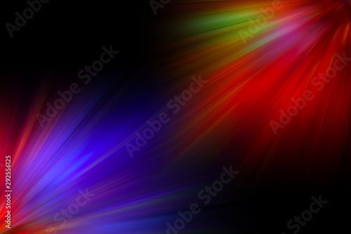 Multicolored rays of light shine of the black background