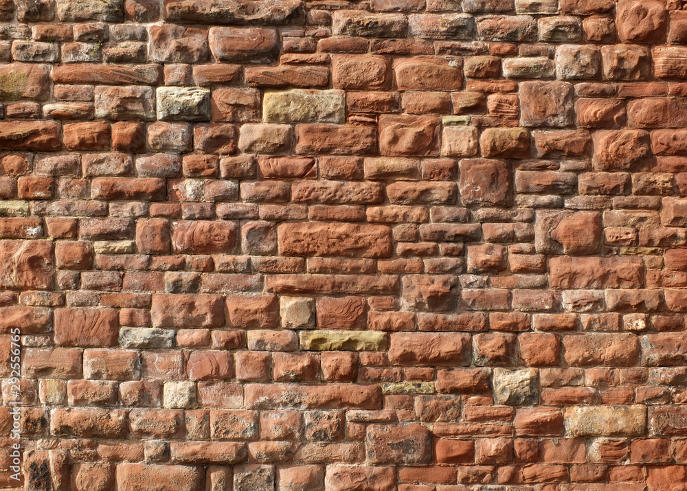large red old sandstone wall with rough textured surface large red old sandstone wall with rough textured surface
