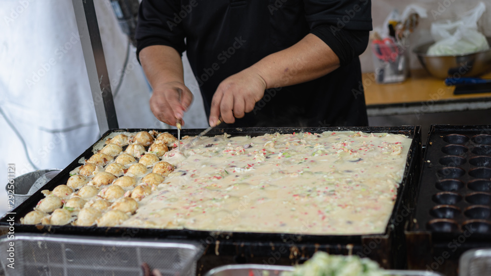 Hand of chef to cooking Takoyaki on hot pan famous food Osaka Japan street food Hand of chef to cooking Takoyaki on hot pan famous food Osaka Japan street food