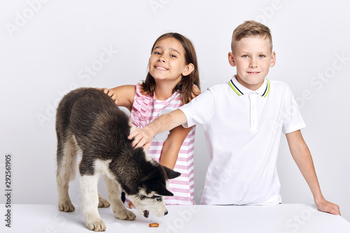 frindly kind kids take cre of their pet, close up portrait, isolated white background, studio shot