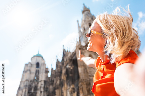 Photography A young woman in a bright orange dress stands on the background of St