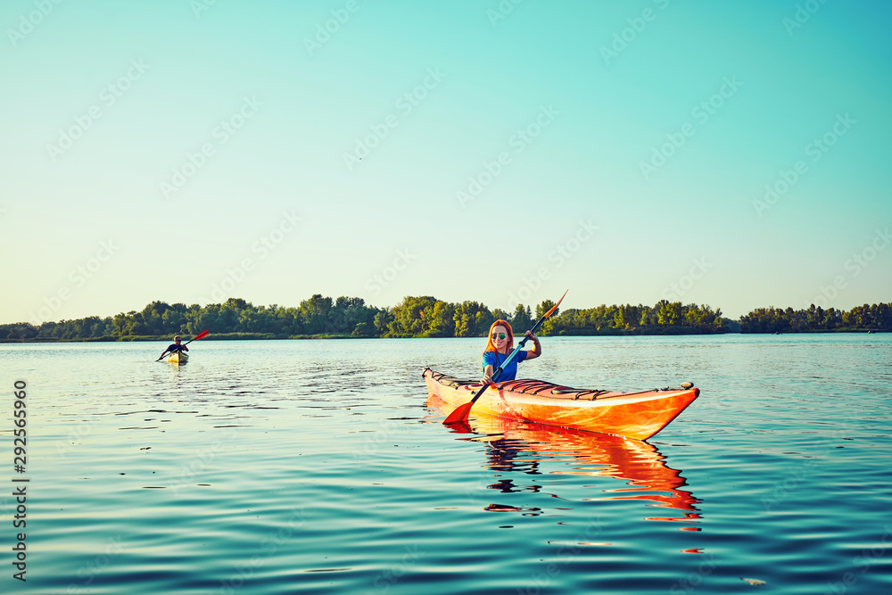 People kayak during sunset in the background. Have fun in your free time.