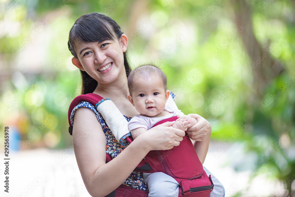 baby feeling happy and smiles with her mother in the garden.Portrait of Asian family. baby feeling happy and smiles with her mother in the garden.Portrait of Asian family.