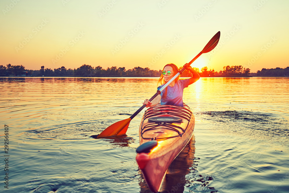 People kayak during sunset in the background. Have fun in your free time. - obrazy, fototapety, plakaty 
