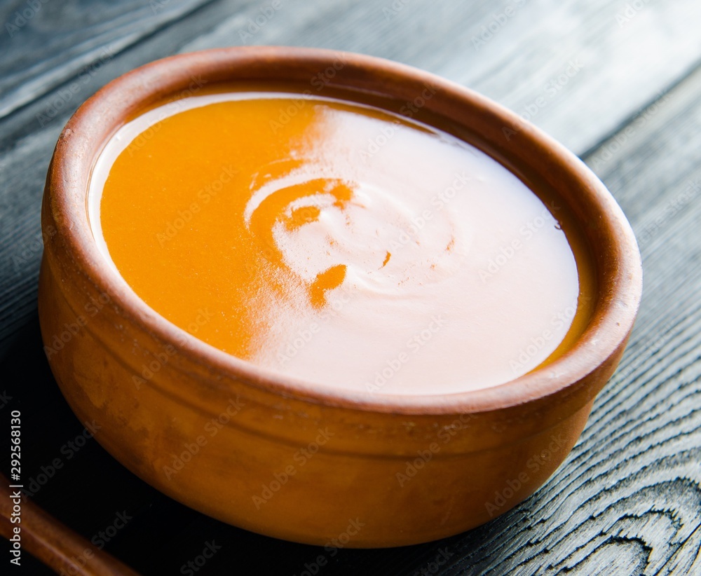 Carrot soup served on the table in bowl Carrot soup served on the table in bowl