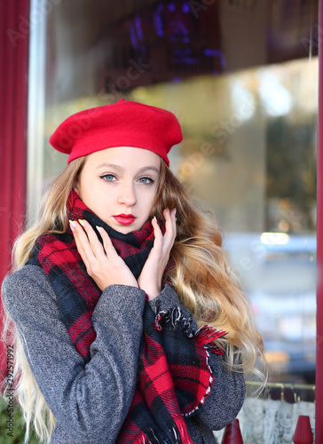 young girl in a red beret at a cafe on the street