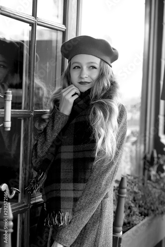  stunning black and white portrait young girl in a beret at a cafe on the street. Autumn
