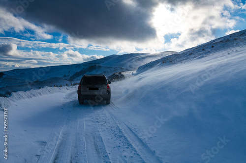 car on road through snowy landscape