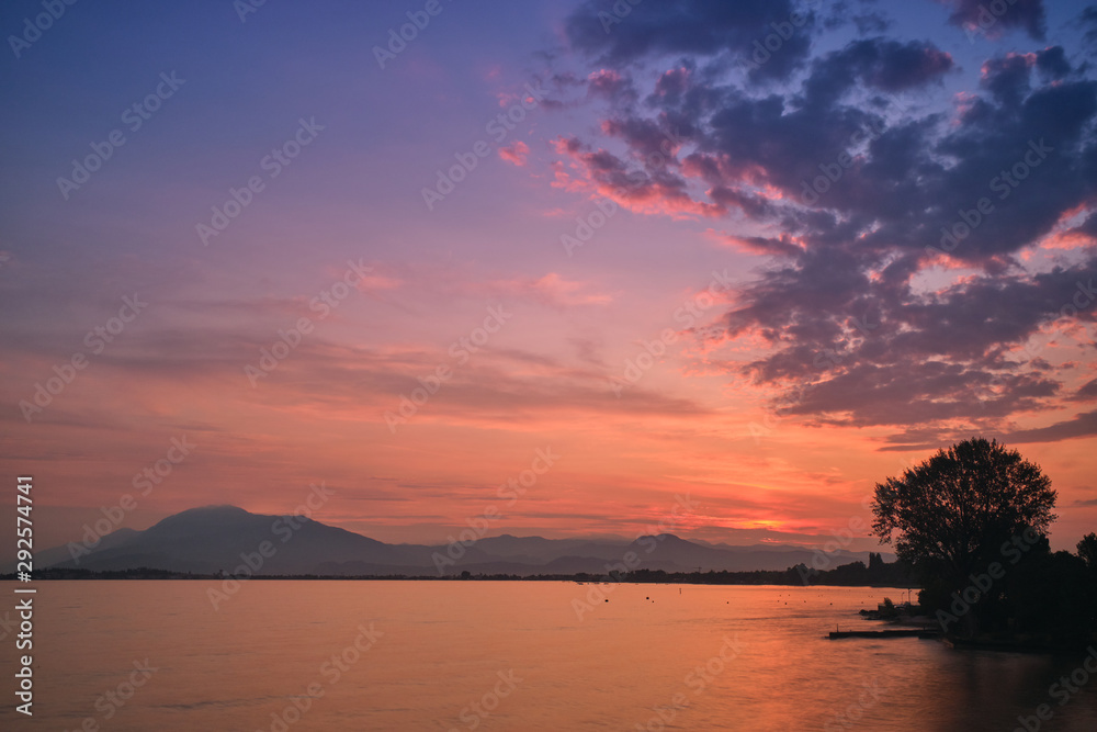 Fototapeta premium Sunrise over the lake. Reflection of the sun in the water.