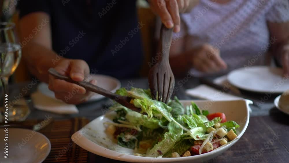 Caesar salad mixing in bowl giving to wife Caesar salad mixing in bowl giving to wife
