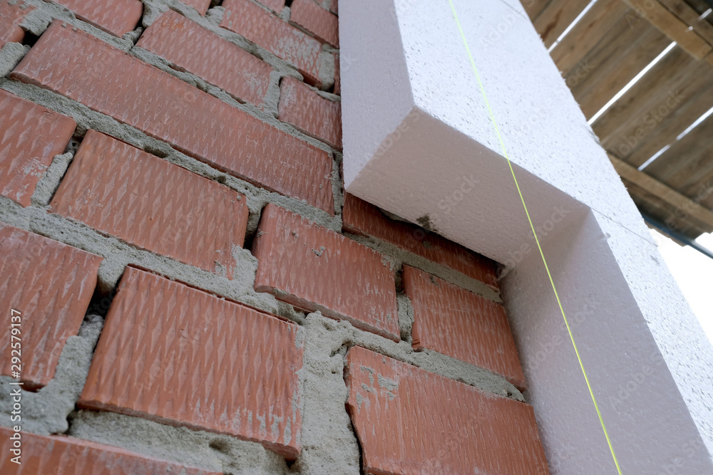 Close-up detail of brick house wall with rigid styrofoam insulation sheet. Modern technology of construction, renovation and energy saving. Alternative for mineral wool, warm comfortable house concept