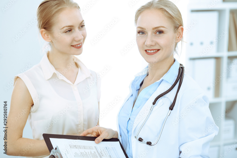 Doctor and patient talking in hospital office while sitting at the desk. Health care and client service in medicine Doctor and patient talking in hospital office while sitting at the desk. Health care and client service in medicine