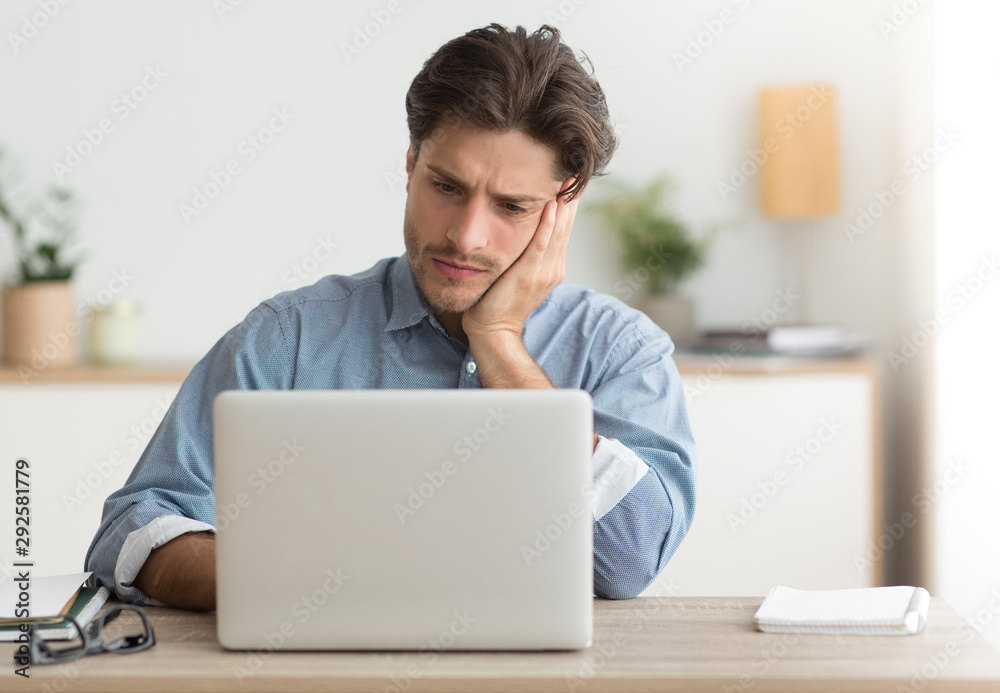 Unhappy Office Manager Sitting At Laptop Working In Office Unhappy Office Manager Sitting At Laptop Working In Office