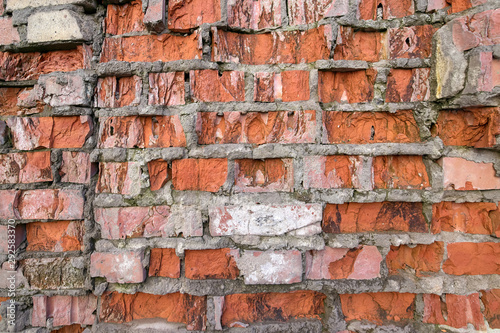 Wall of red broken bricks, background and texture