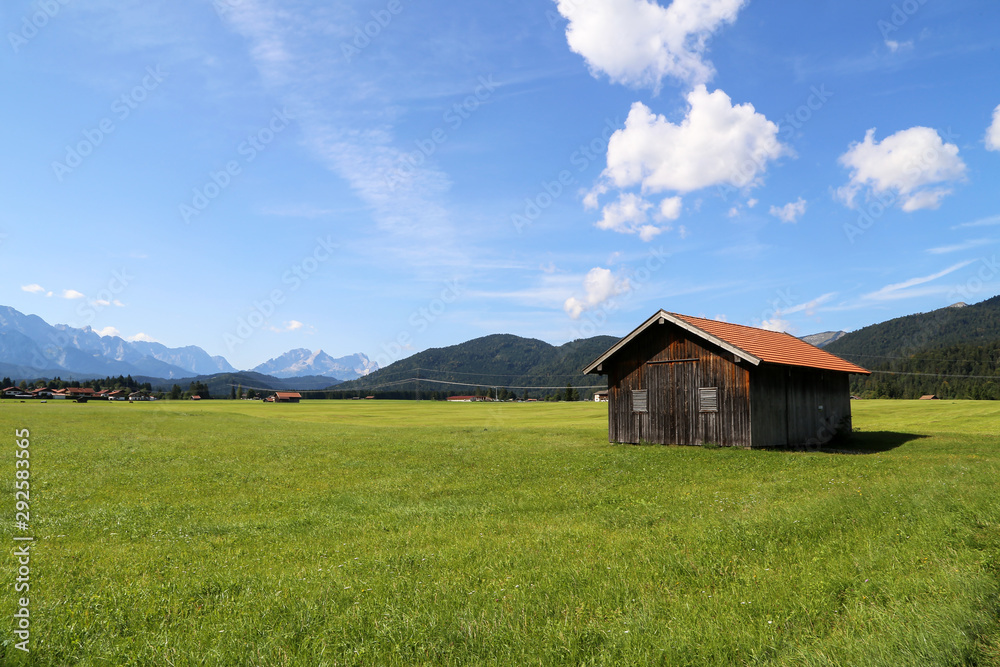 Mountain huts on green meadows in the Alps