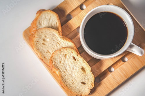bread for breakfast, with cup of coffee over rustic wooden background with copy space. Morning breakfast with coffee and toasts.