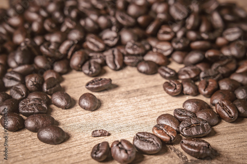 Coffee on wooden background. Brown roasted coffee beans, seed on dark background. Espresso dark, aroma, black caffeine drink. Closeup isolated energy mocha, cappuccino ingredient.