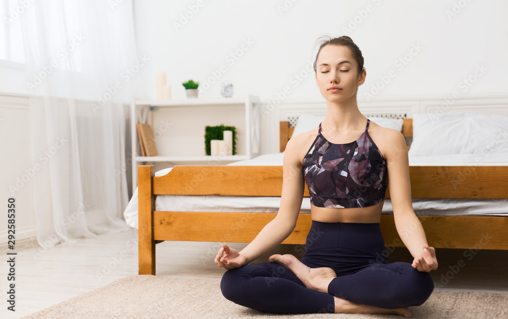 Young woman exercicing in lotus position in bedroom Young woman exercicing in lotus position in bedroom