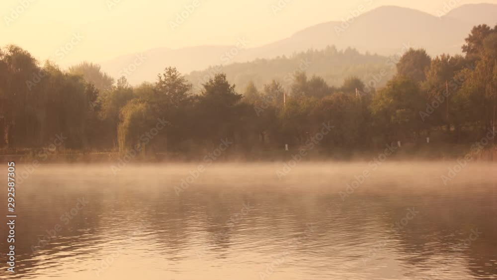 Foggy morning on a lake during sunrise. Summer landscape on a mountain lake. Peaceful summer scene.