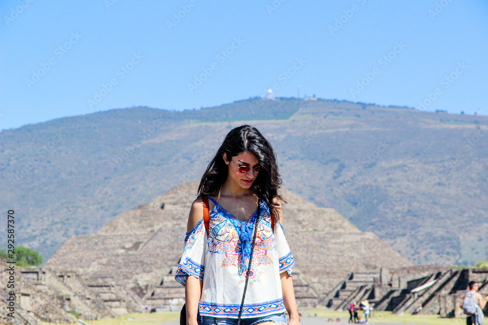 Pyramid of Moon, Teotihuacan background behind walking woman in Mecixo City