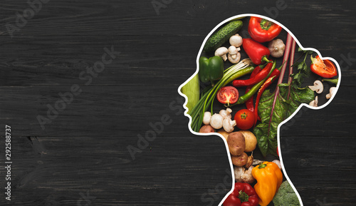 Woman with fresh vegetables in her body on wood