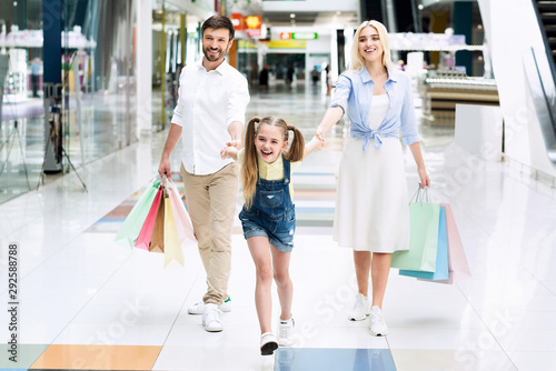 Family Of Three Doing Shopping Walking In Mall