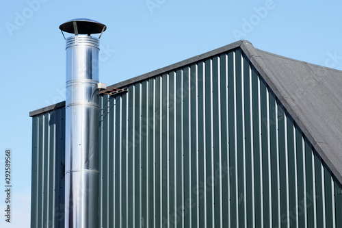 Flue chimney fixed to building exterior wall stainless steel from exhaust boiler plant room