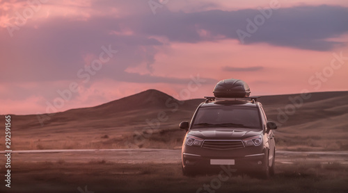Off-road car in the mountains at sunset