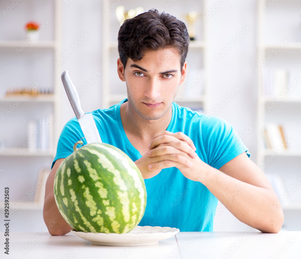 Fototapeta premium Man eating watermelon at home
