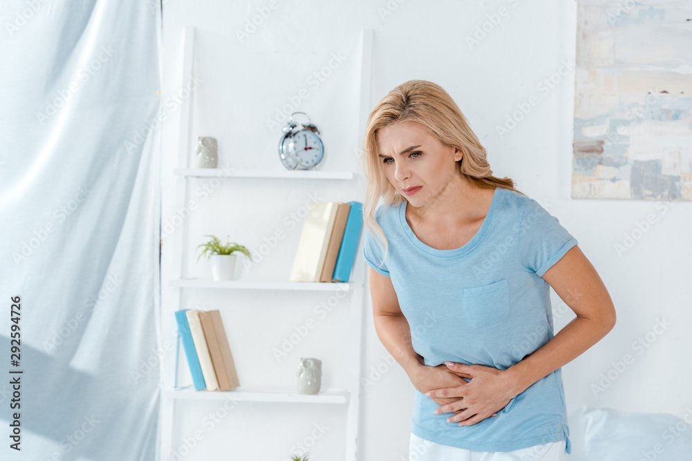 sick woman having stomach ache at home