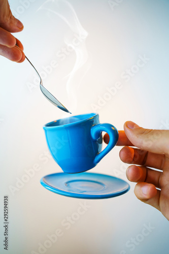 Fotografie Floating blue cup of espresso with spoon in hand