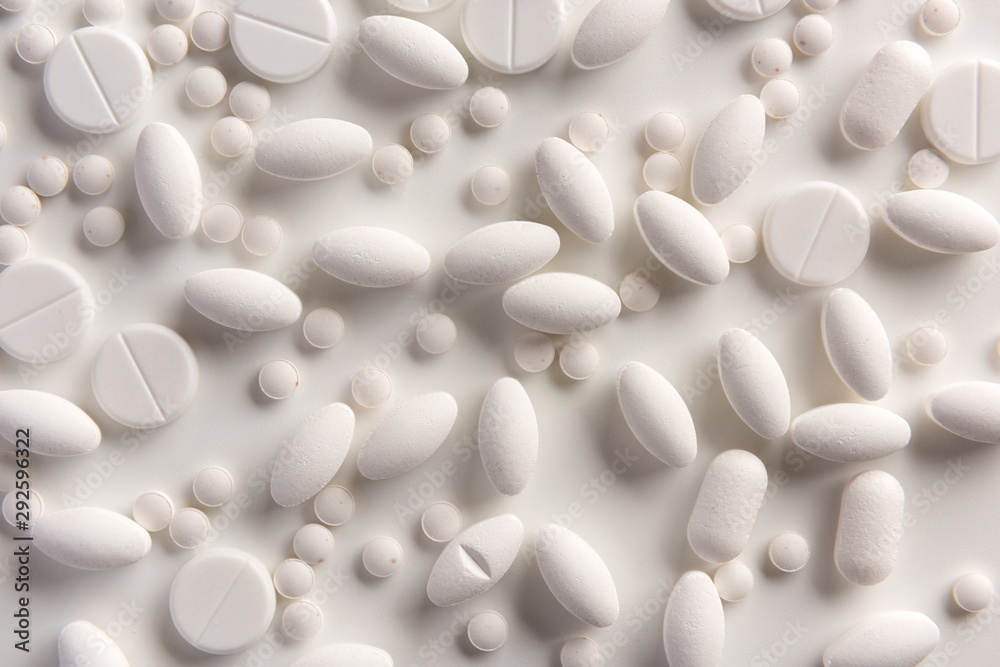 White pills on white background. Flat lay.