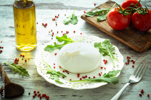 Burrata, Italian cheese with tomatoes, spices, argugula and olive oil and balsamic vinegar