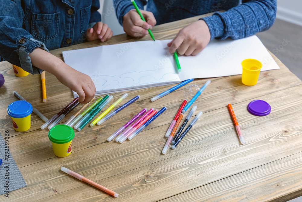 Dad and daughter simultaneously draw a top view on paper ...
