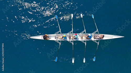 Aerial top down photo of sport canoe operated by team of young men in open ocean deep blue sea photo